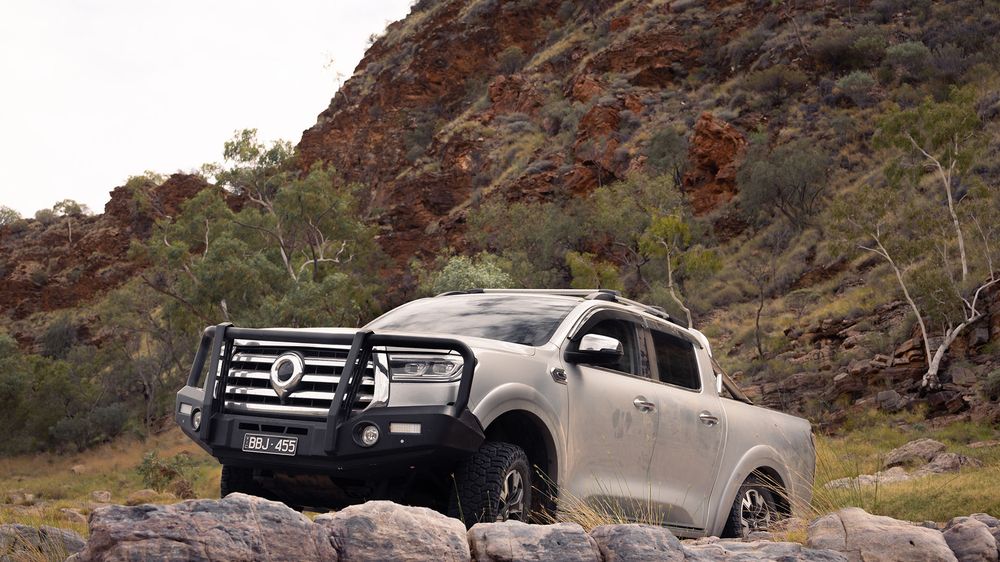 A Slate Grey GWM Ute Cannon parked on a large rock with a large dirt cliff in the background
