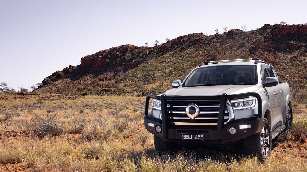 A Slate Grey GWM Ute Cannon with a black bull bar parked next to a soil dune