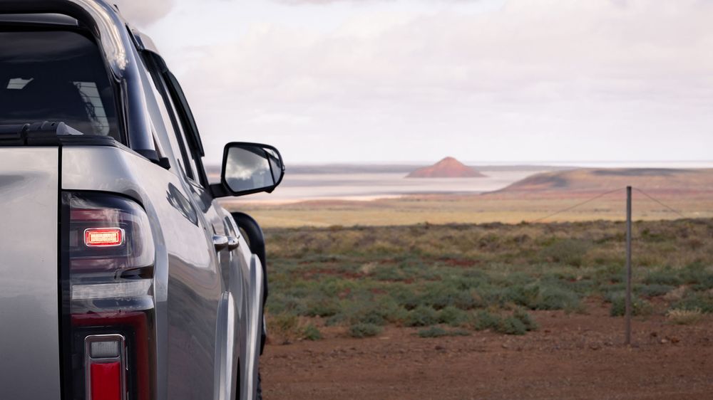 Close up of the rear tail lights on a Slate Grey GWM Ute Cannon with the desert and beach in the distance
