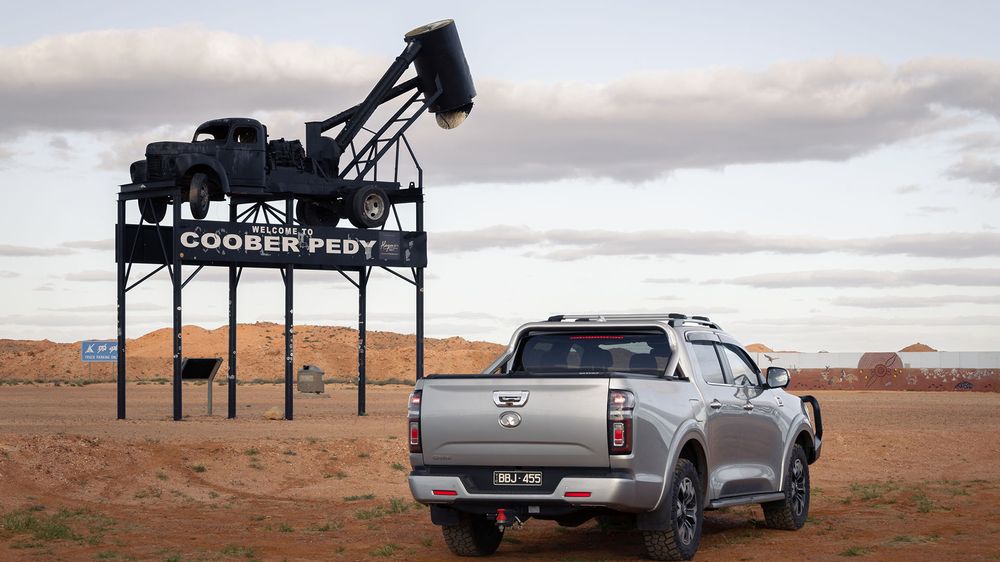 Slate Grey GWM Ute Cannon parked under the famous Cooper Pedy signage in the desert
