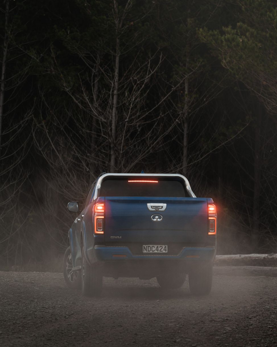 Sapphire Blue GWM Ute Cannon kicking up dust on a gravel road in the willderness