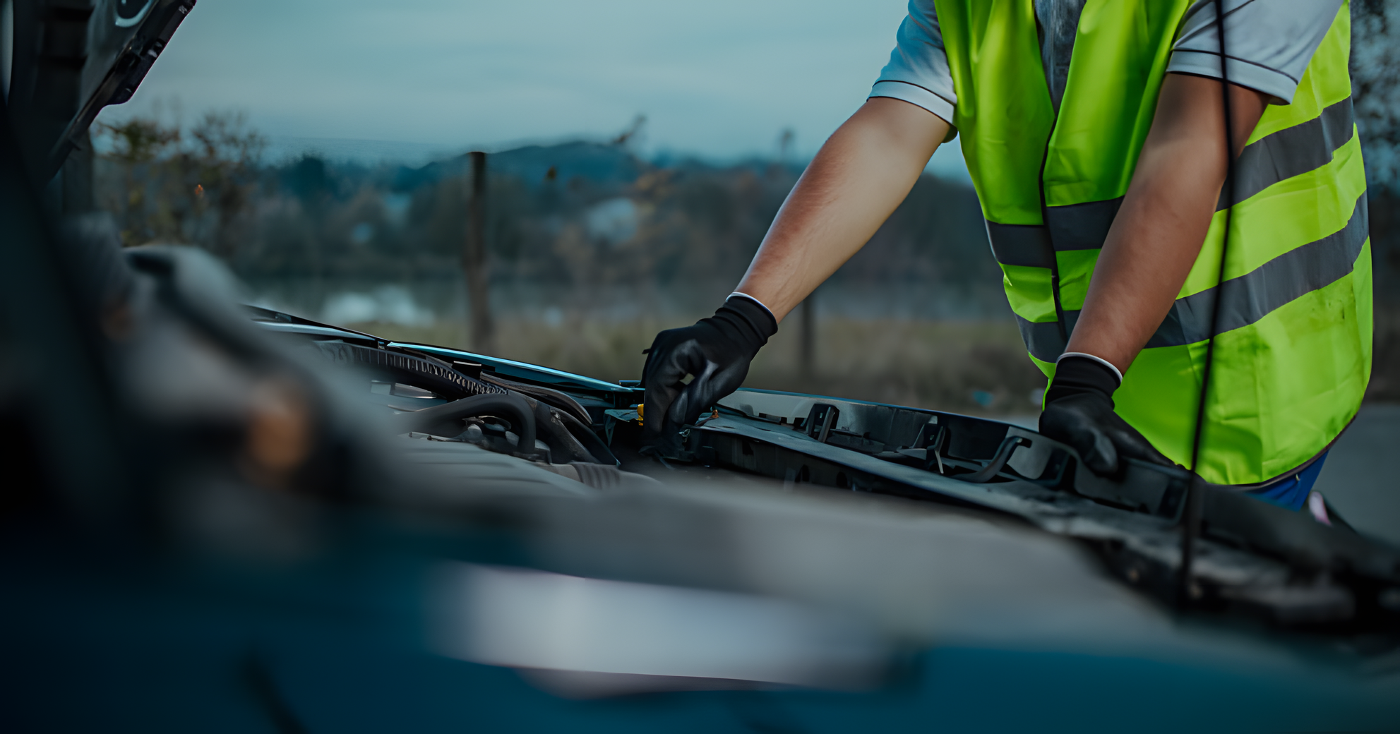 Service technician with a bright green safety vest working on the engine of a GWM vehicle
