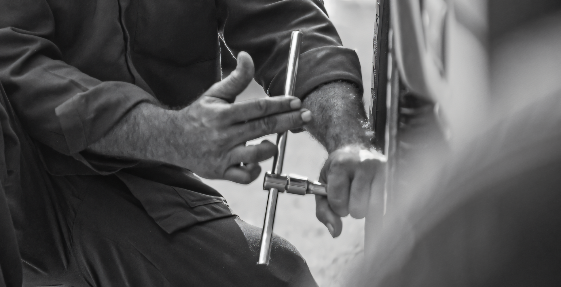 Service technician using a tyre iron to change undo the lugs nuts of the wheel