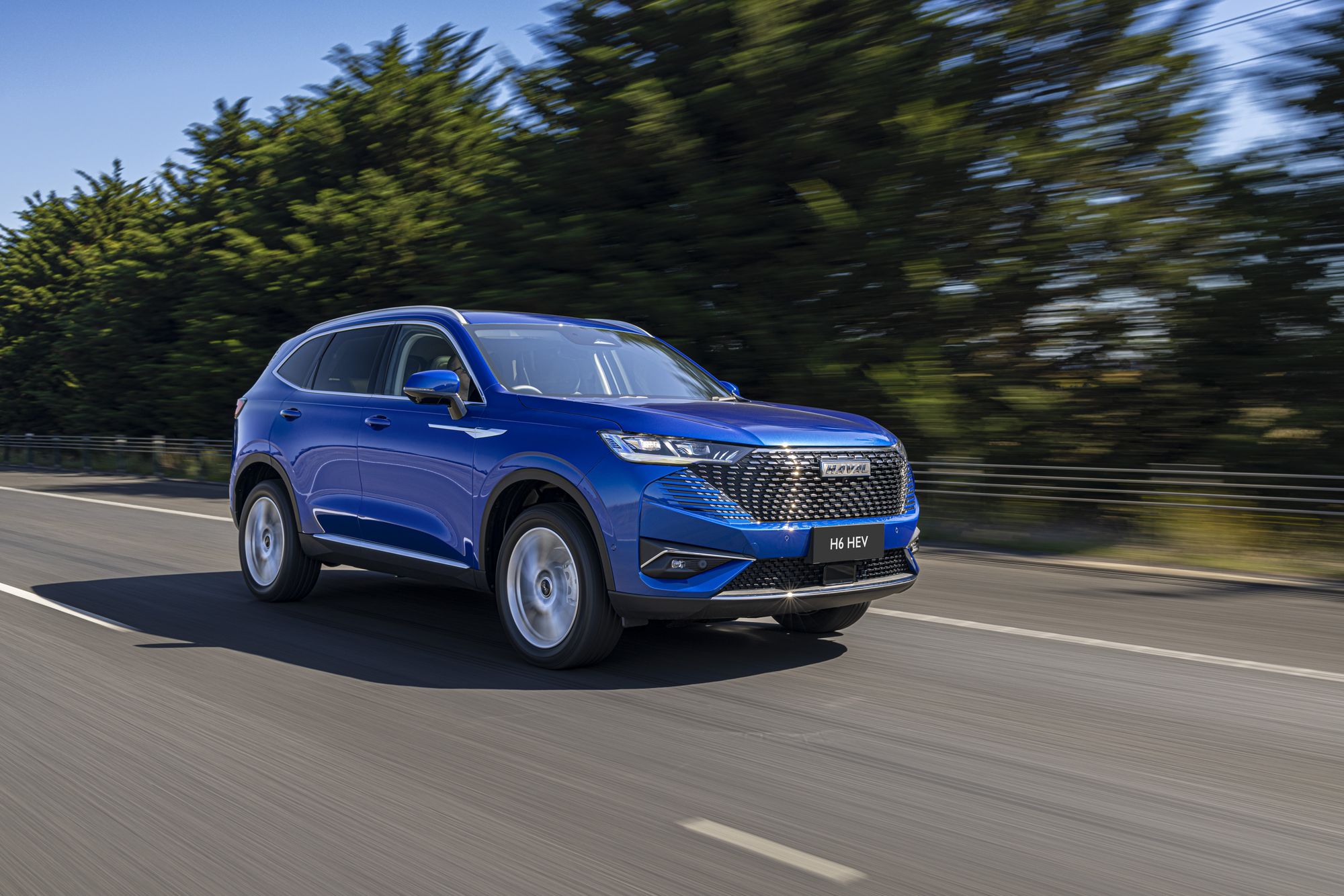 Sapphire Blue GWM Haval H6 driving through the country road