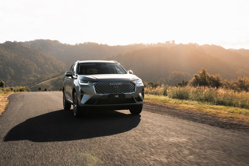 Ayers Grey GWM Haval H6 driving towards the camera on rural roads with hills in the background
